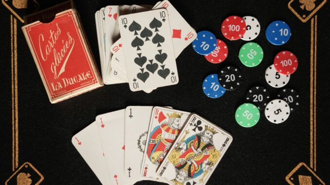 L'Art de Vivre : Pourquoi les Divertissements et Loisirs sont Essentiels à Notre Épanouissement Une table noire surmontée de cartes à jouer et de jetons pour les divertissements et loisirs en famille ou entre amis