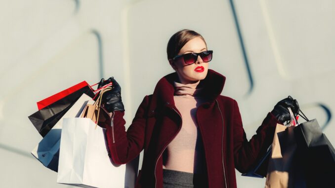 Blog Mode et Beauté : Comment Créer un Univers Inspirant et Tendance en Ligne photo d'une femme à la mode tenant des sacs en papier blanc et noir