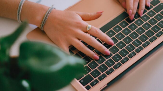 Blogueuse et Passionnée du Web : Explorer l'Univers du Blogging et de la Création de Contenu en Ligne Une blogueuse tapant sur un ordinateur portable sur un bureau