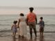 Une famille moderne profite des joies de la plage et du coucher de soleil